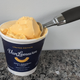Pint of Van Leeuwen Kraft Macaroni & Cheese ice cream with scooper on countertop